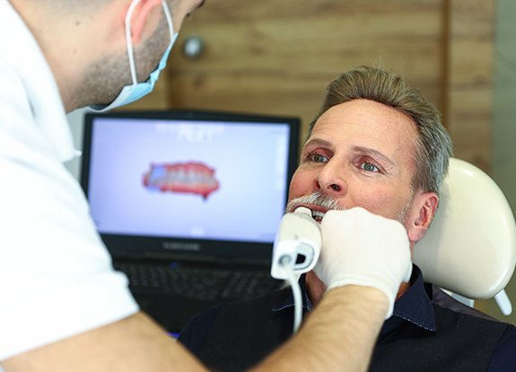 Dentist capturing images of patient's smile using 3D iTero scanner
