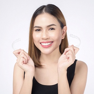 young woman holding clear aligners