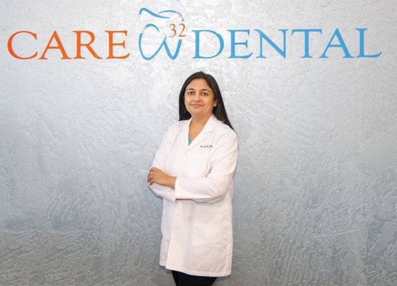 Doctor Desai in front of Care 32 Dental of Grand Prairie sign