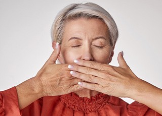 Lady covers mouth with hands