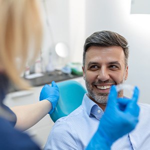 Man smiling at dentist about to give him Invisalign 