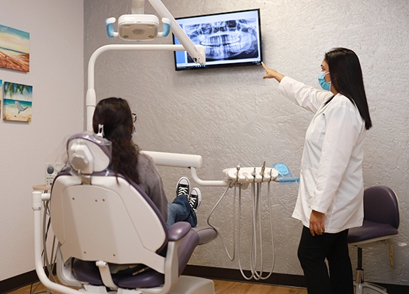 Dentist and patient looking at digital dental x-rays