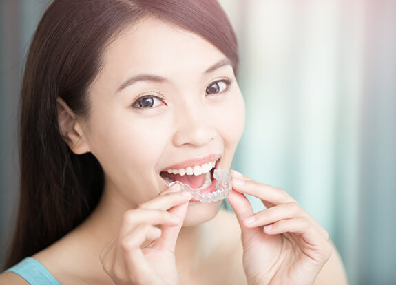 Patient placing an Invisalign tray