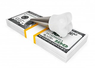 Dental implant in Grand Prairie resting on stack of money