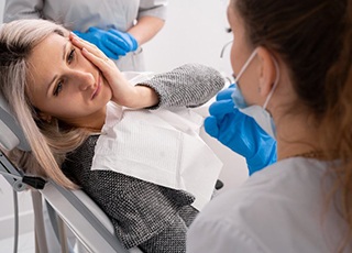 Lady with oral pain looks to dentist