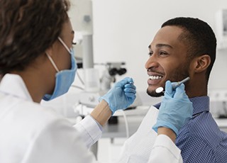 man at a checkup with his implant dentist in Grand Prairie 
