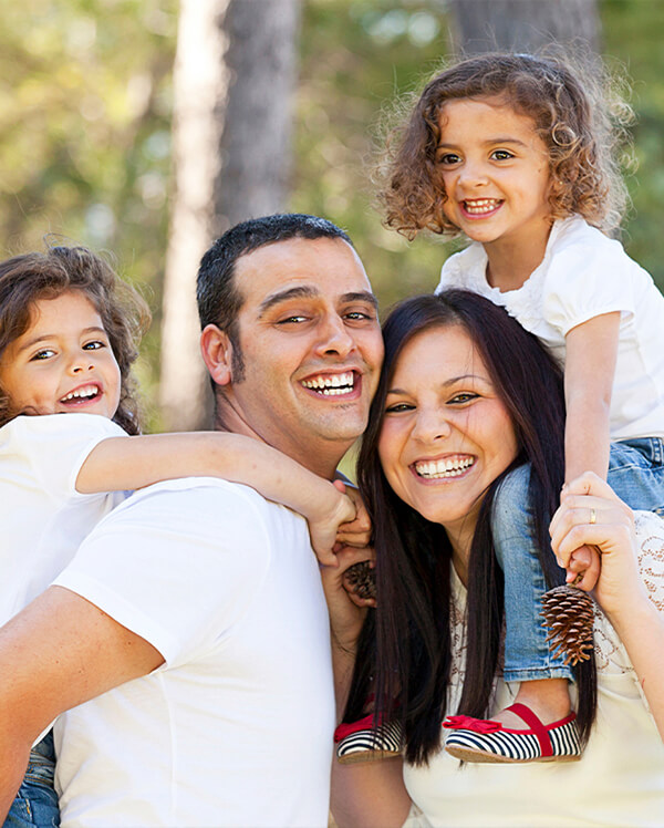 Family of four smiling outdoors