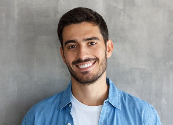 a man smiling after undergoing Invisalign treatment