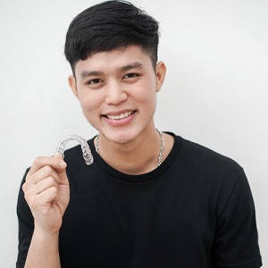 man smiling holding invisalign