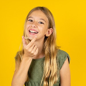 Teen girl putting on Invisalign tray