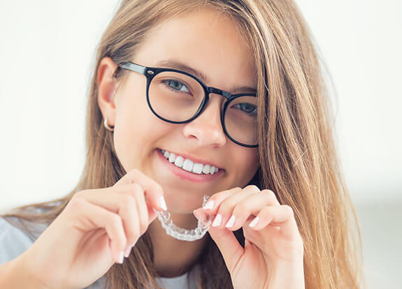 Teen girl placing Invisalign tray