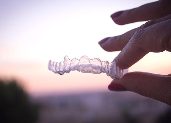 Hand holding an Invisalign tray