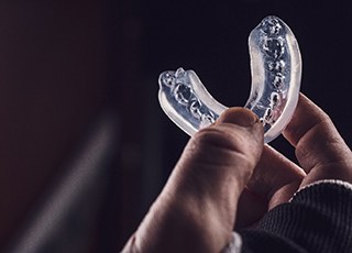 Man holding clear mouthguard
