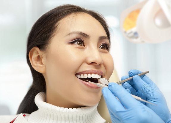 Woman receiving dental checkup and teeth cleaning