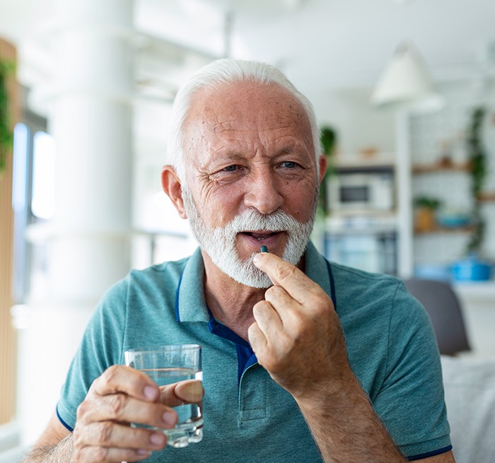 An older man taking a sedative pill before he visits his dentist