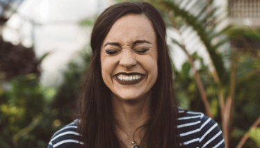 Laughing woman with healthy smile after periodontal therapy