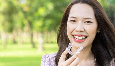 Woman placing Invisalign tray