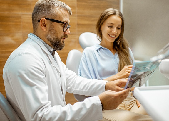 Dentist talking to patient about porcelain veneers in Grand Prairie