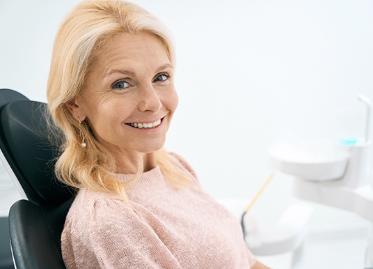 Senior female dental patient in a light pink shirt