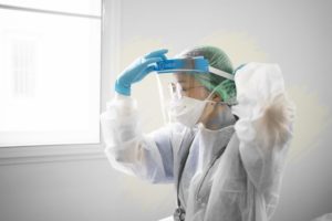 dental professional putting on increased PPE