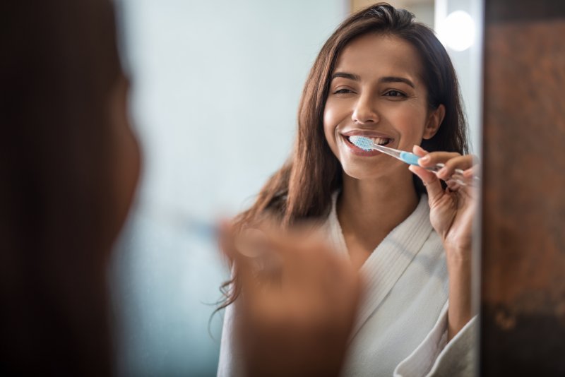 A woman brushing her teeth as instructed by her dentist in Grand Prairie