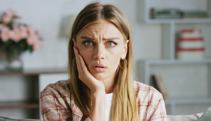Woman looking worried, holding jaw