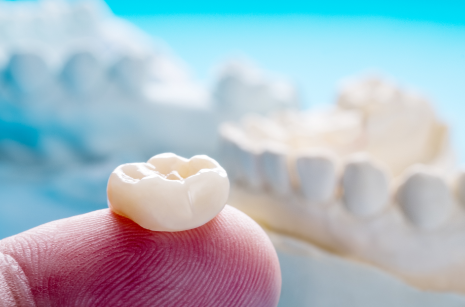 Finger holding a dental crown